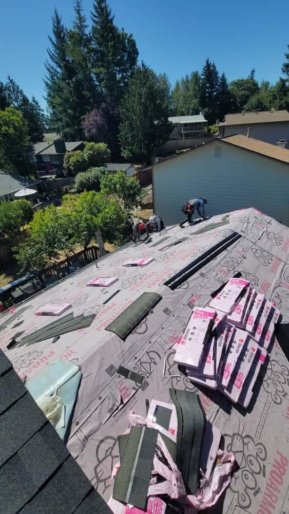 Overstate crew installing synthetic underlayment and shingle bundles on a full roof replacement